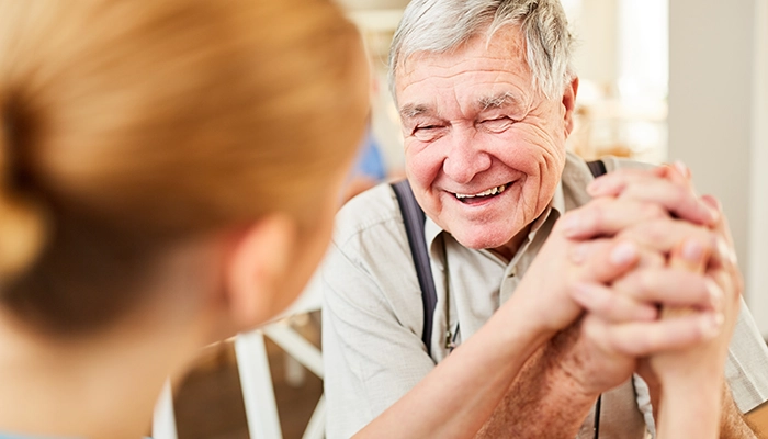 smiling elderly man holding hands